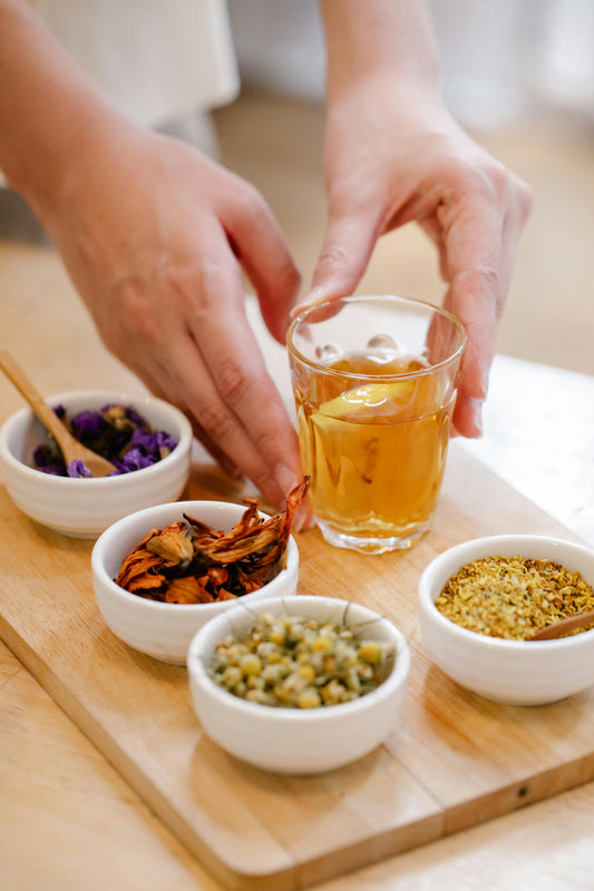 A warm cup of Caribbean herbal tea surrounded by tropical leaves and fresh botanicals, evoking a spring wellness ritual