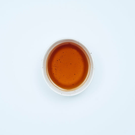 "Smooth September herbal tea blend with cayenne pepper, bay leaf, and mullein in biodegradable tea sachet bags inside a 16oz resealable pouch, displayed beside a steaming tea mug."